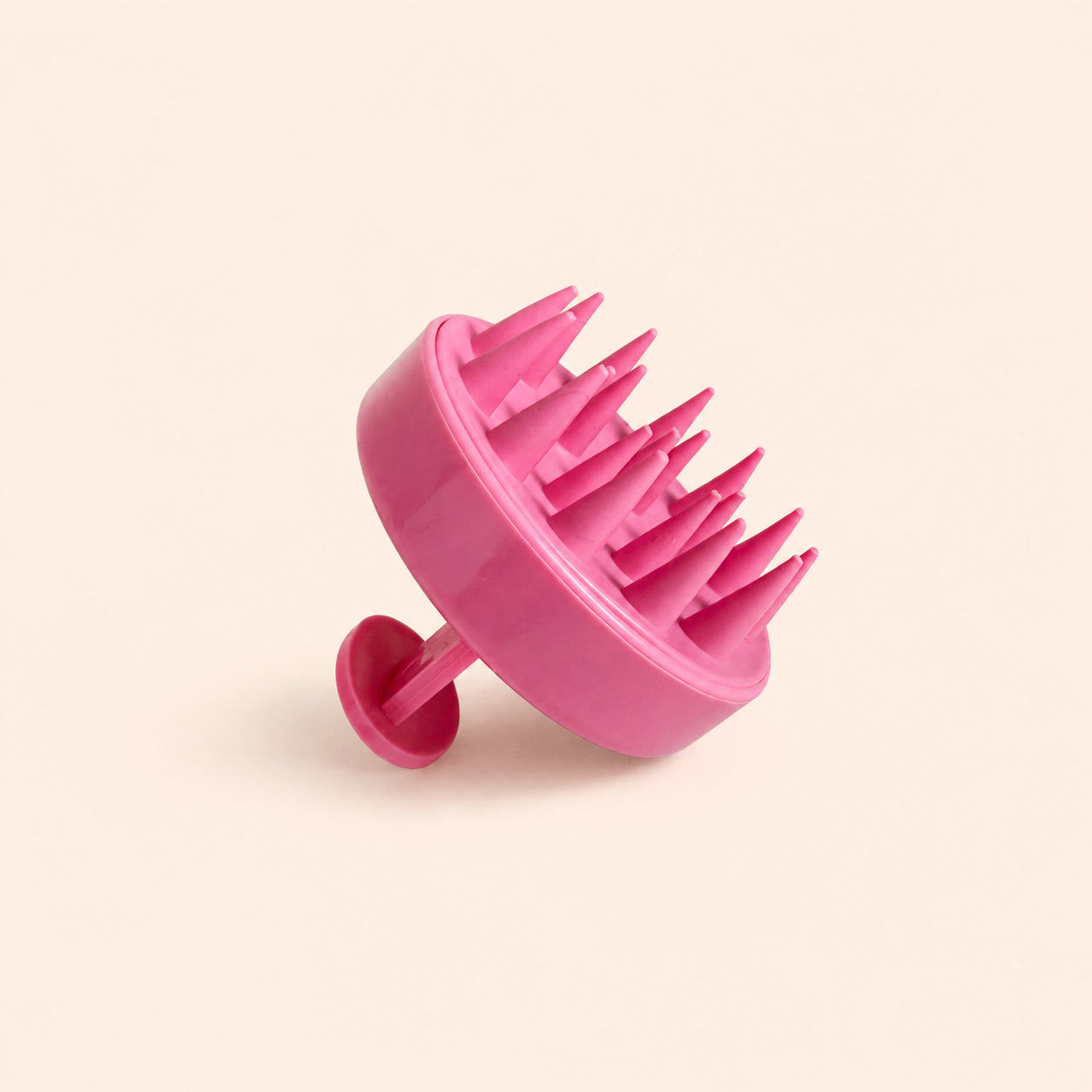 Pink silicone scalp massager seen from below